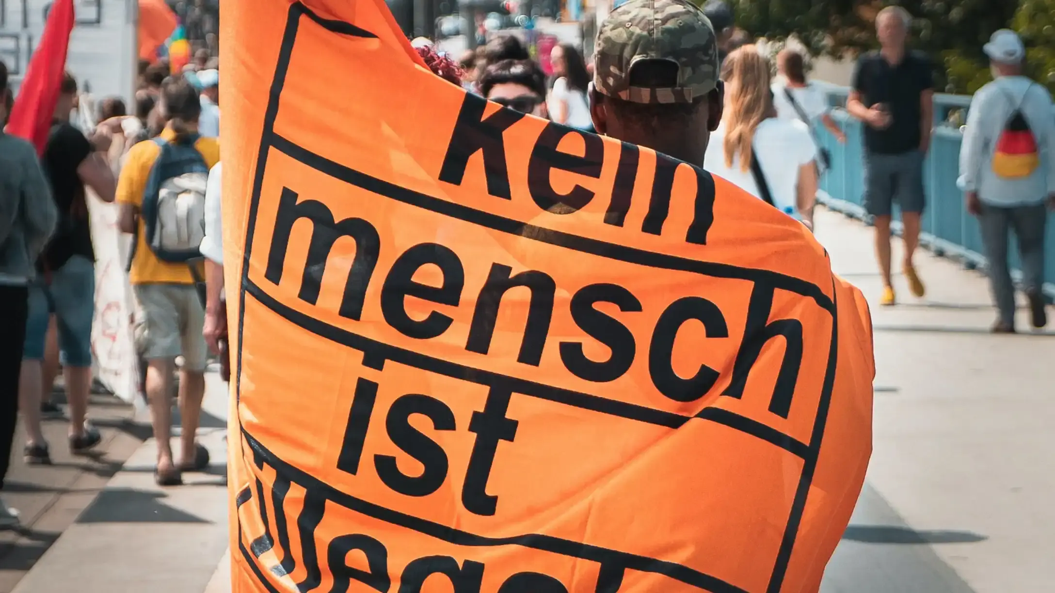 Two people with a protest flag wrapped around them