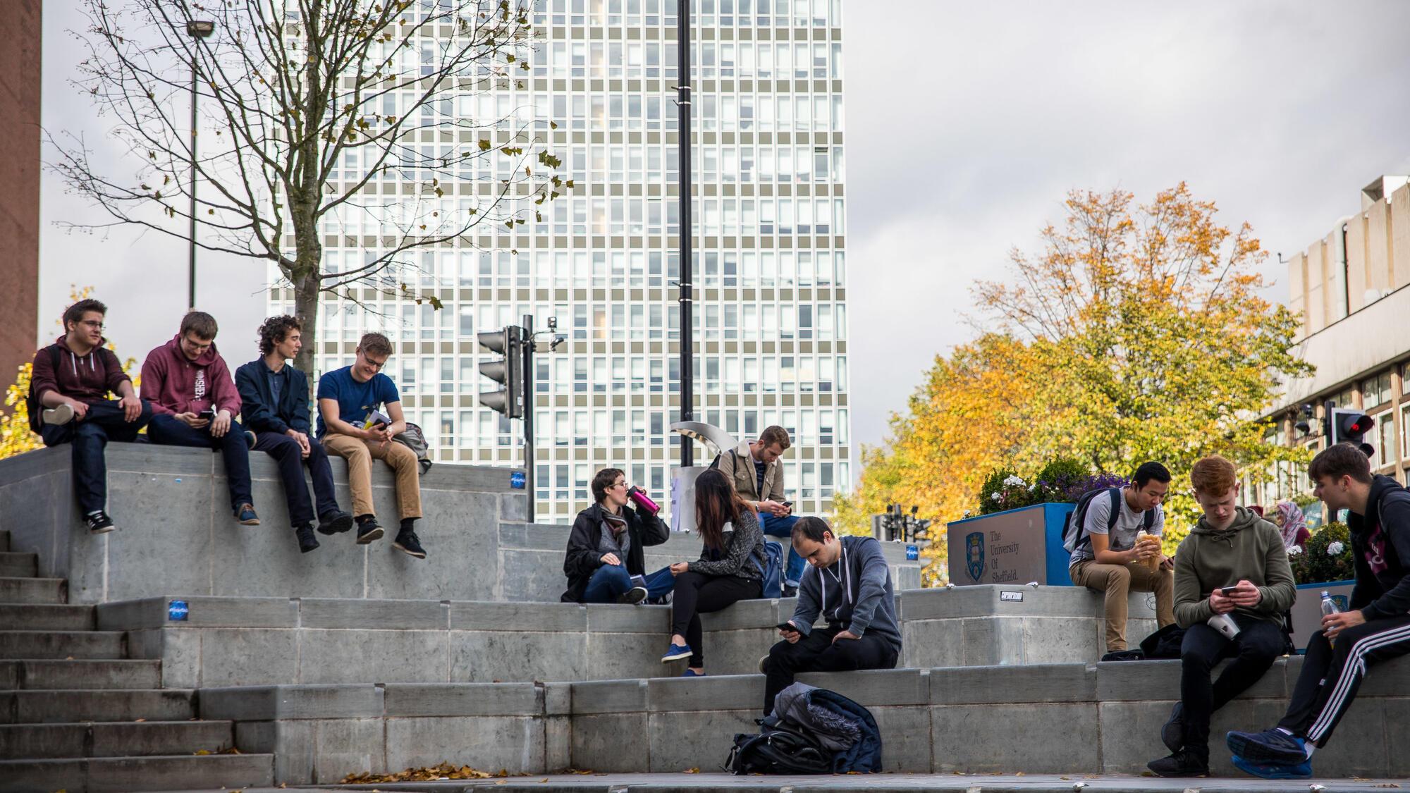 Young people sitting on steps in front of the Arts Tower in Sheffield