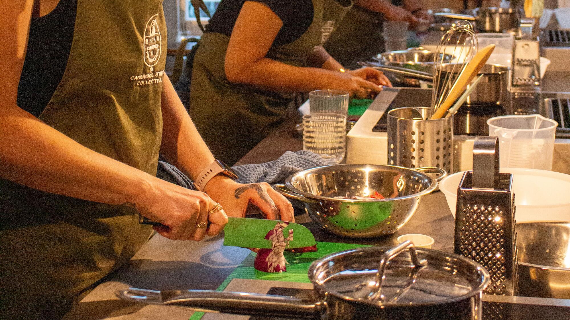 A woman chopping vegetables at a cooking workshop 