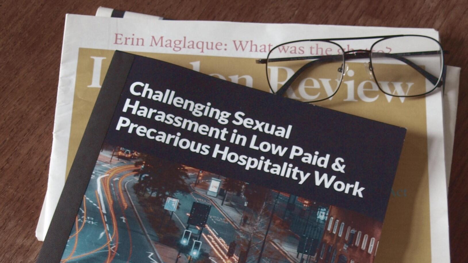 A leaflet titled 'Challenging sexual harassment in low paid and precarious hospitality work' on a desk