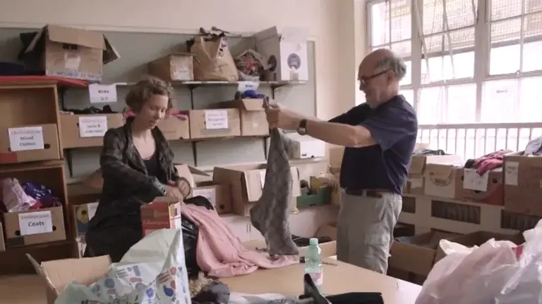 Jules Holroyd and colleague boxing up clothes for refugees