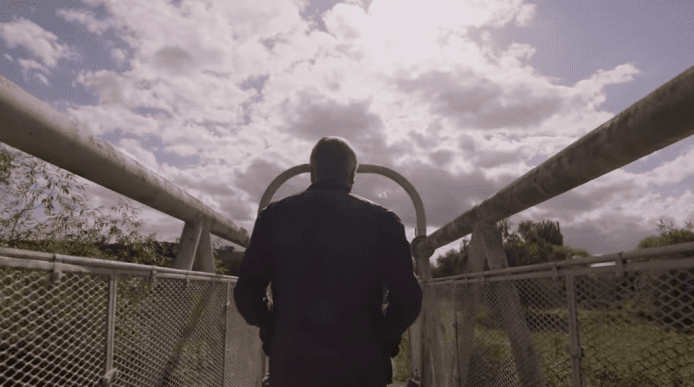 Film still of Simon Armitage on a bridge