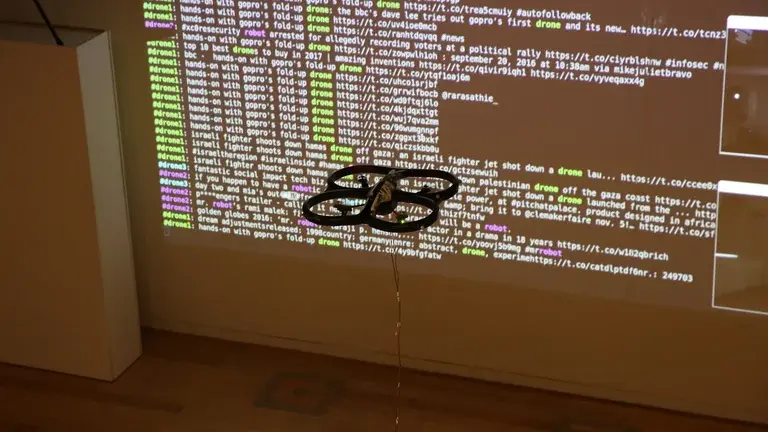 A drone hovering in front of a projection displaying web data