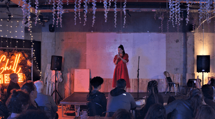 Leyla Josephine on stage performing poetry at Off the Shelf 2022