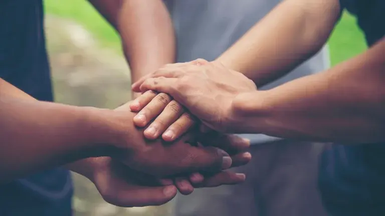 Group of people putting hands together