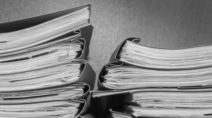 A stack of old paper folders on a shelf