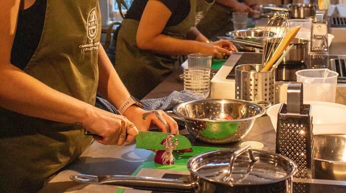 A woman chopping vegetables at a cooking workshop 