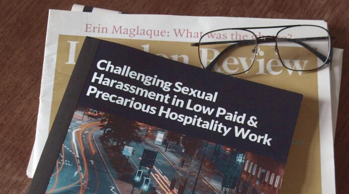 A leaflet titled 'Challenging sexual harassment in low paid and precarious hospitality work' on a desk