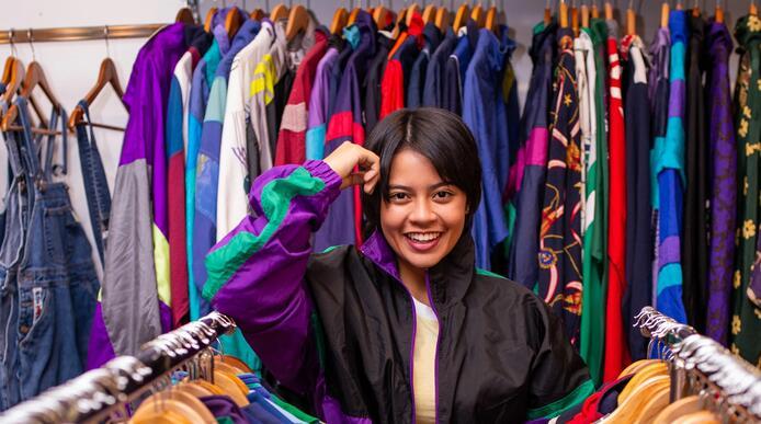 A woman stands amongst racks of vintage sportswear