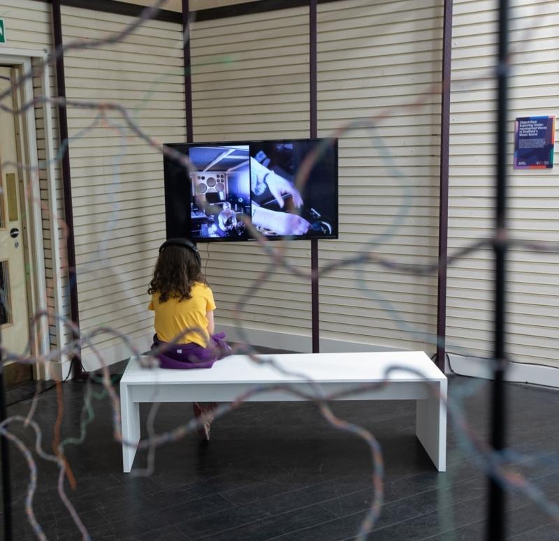 A young girl watching the Object|ified film installation at Event Central
