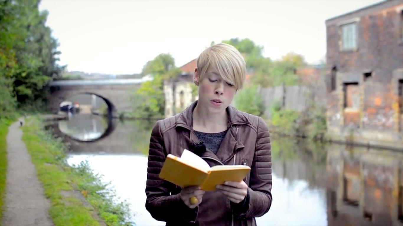 Film still of Helen Mort reading aloud by the canal