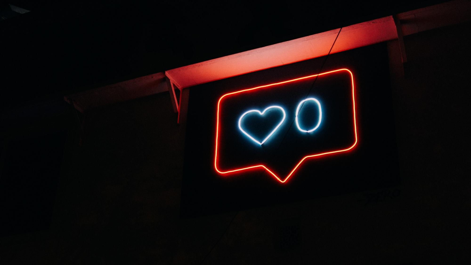 A neon light in the shape of an Instagram 'like' graphic