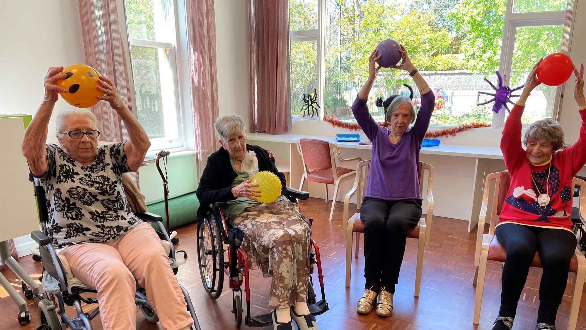 A group of elderly women taking part in a wellness therapy session 