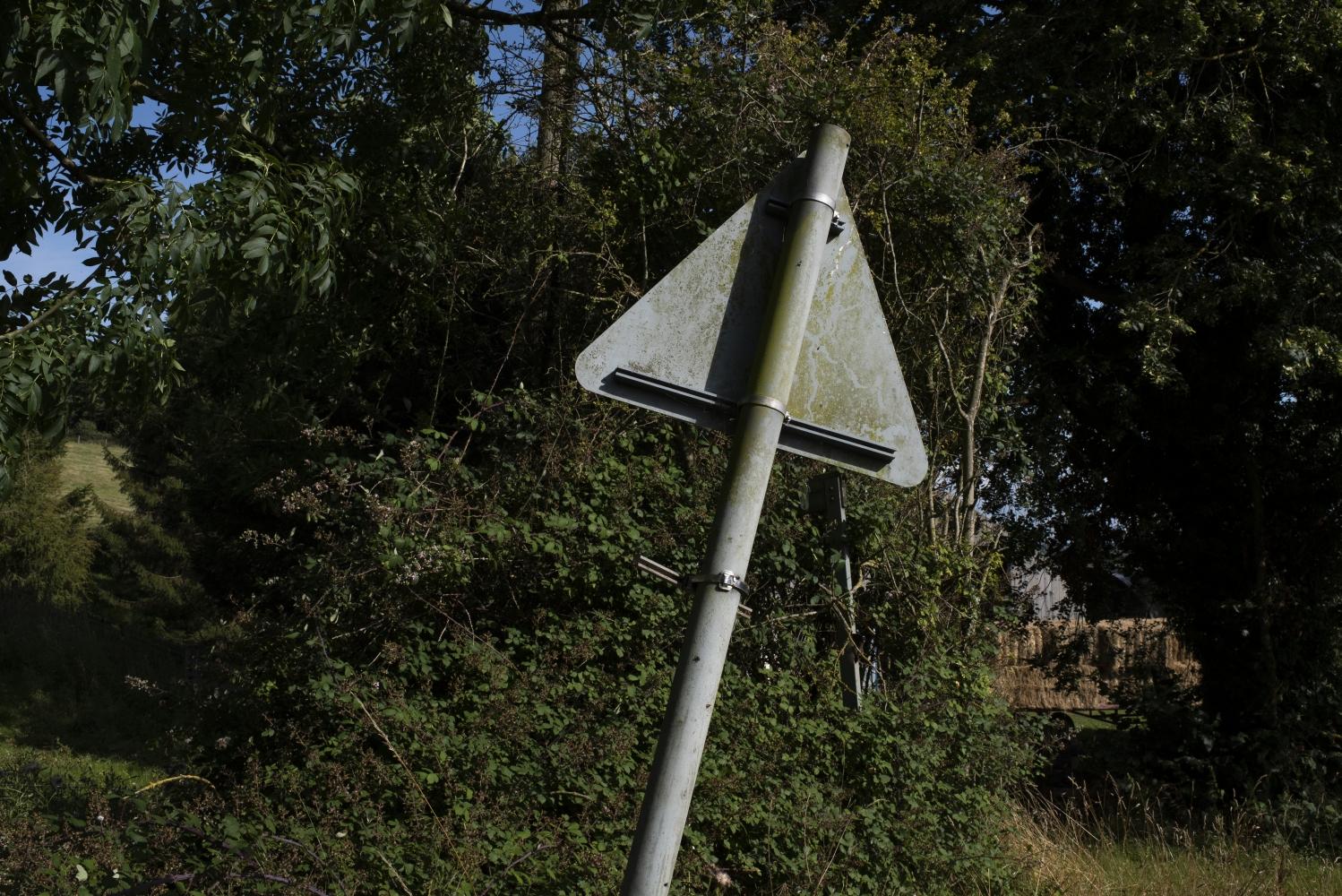 The back of a traffic sign on a country road