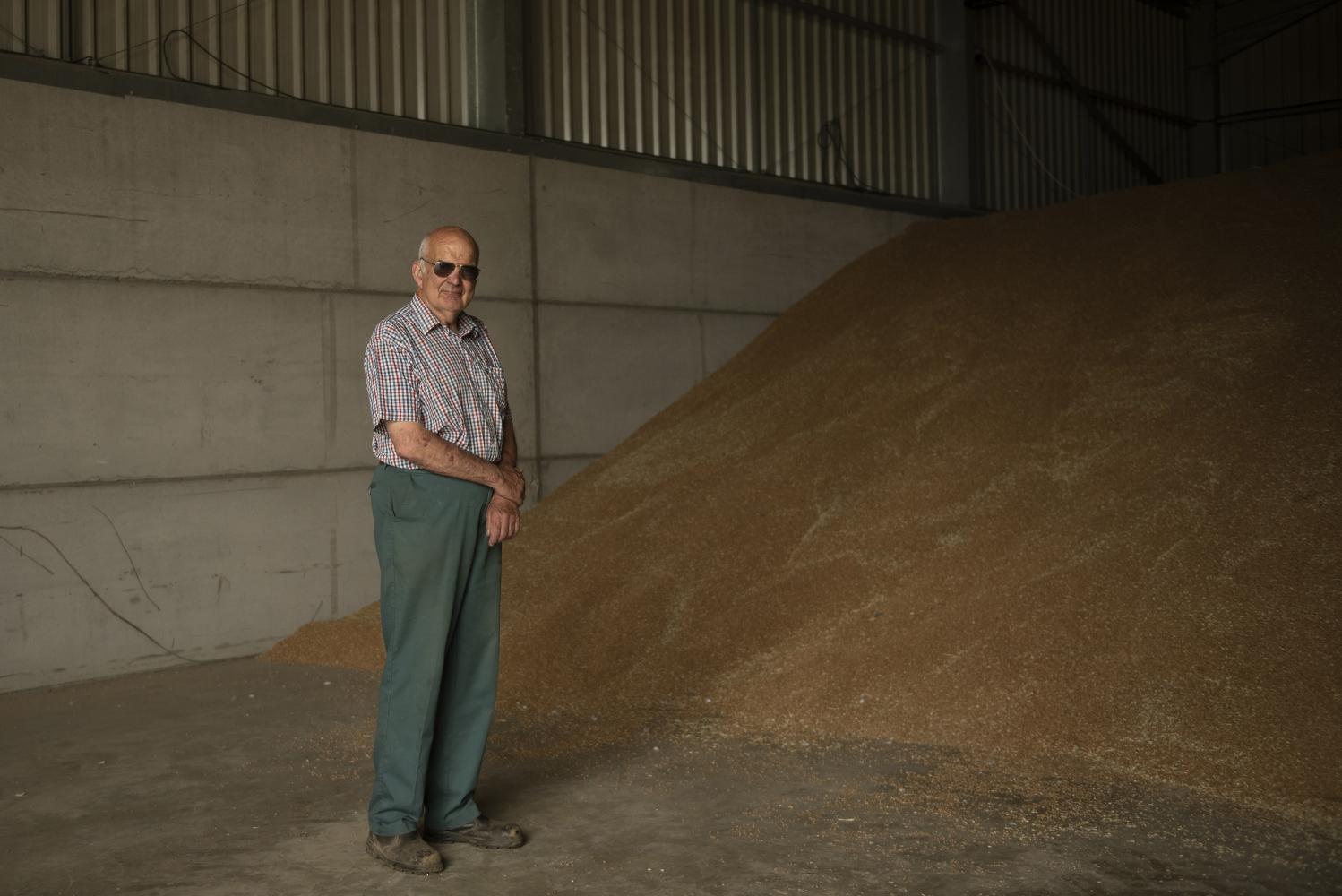 A man standing in front of a pile of grain