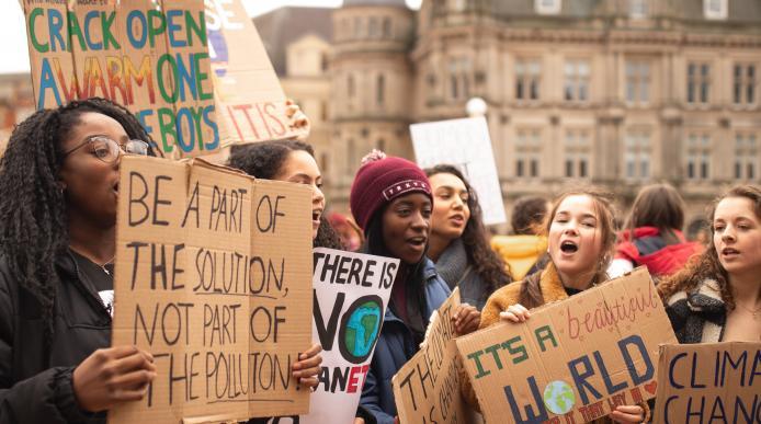 A group of young people at a protest holding placards about climate change