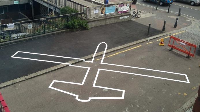 The outline of a drone painted onto a road 