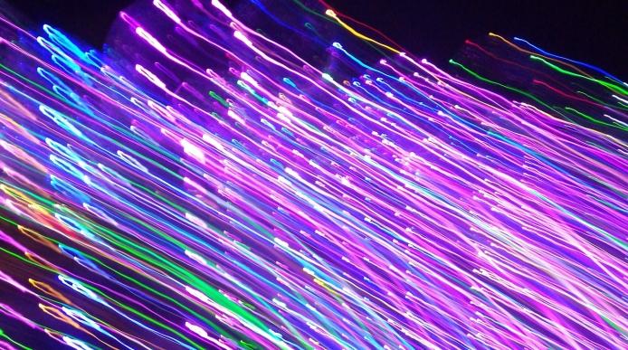 Abstract photograph of neon light strands against a black background