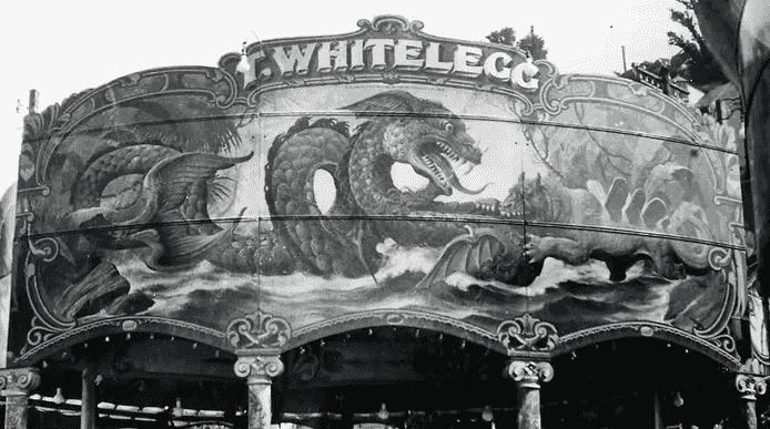 Black and white photograph of fairground ride artwork depicting a dragon and tiger fighting